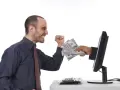 Uśmiechnięty mężczyzna otrzymuje stos banknotów z ekranu komputera. To symbol zarabiania na klikaniu.