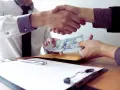 Uścisk dłoni i przekazanie gotówki. To może być początek transakcji, gdzie pozyczka pod weksel jest kluczowa.