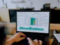 Analiza danych na laptopie, pokazująca wyniki kampanii i statystyki dotyczące jednorazowych zleceń online.