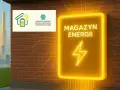 Neonowy znak "Magazyn Energii" obok logo NFOŚiGW, symbolizującego dofinansowanie OZE. W tle futurystyczne miasto.