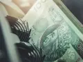 Stos banknotów 100 zł, część mechanizmu maszyny liczącej. Szybkie vivus przelewy w nocy.