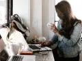 Kobieta pracuje przy laptopie, pijąc kawę. To idealne miejsce do rozwijania swoich freelancer zarobki.