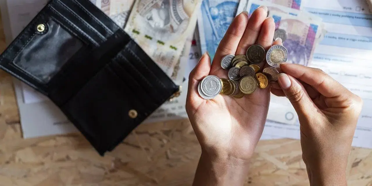 Dłonie liczą monety i banknoty obok otwartego portfela. Szybka, bezpieczna chwilówka to rozwiązanie, gdy brakuje gotówki.