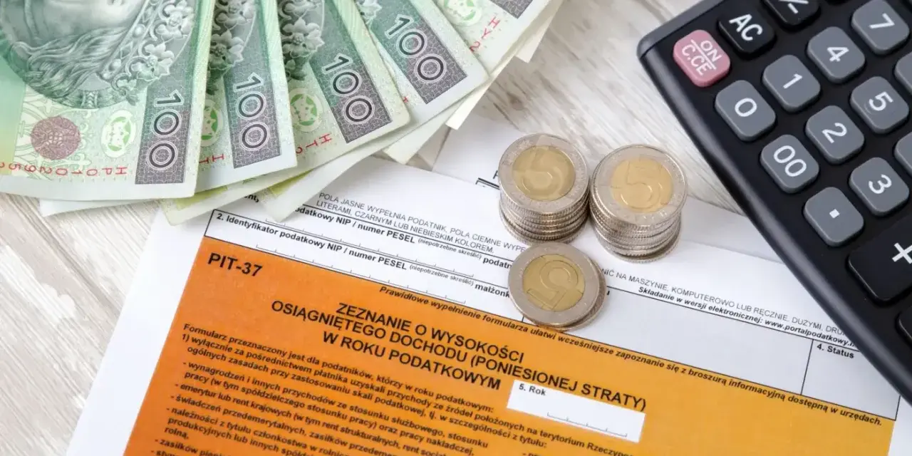 Zestawienie PIT-37, banknoty 100 zł, monety i kalkulator. Możliwy dochód do 30 tys. zł.