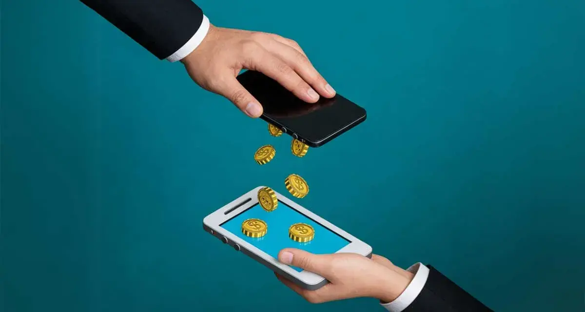 Przelew pieniędzy między telefonami. Złote monety spadają z jednego smartfona na drugi, symbolizując pismo o zwrot refinansowania.