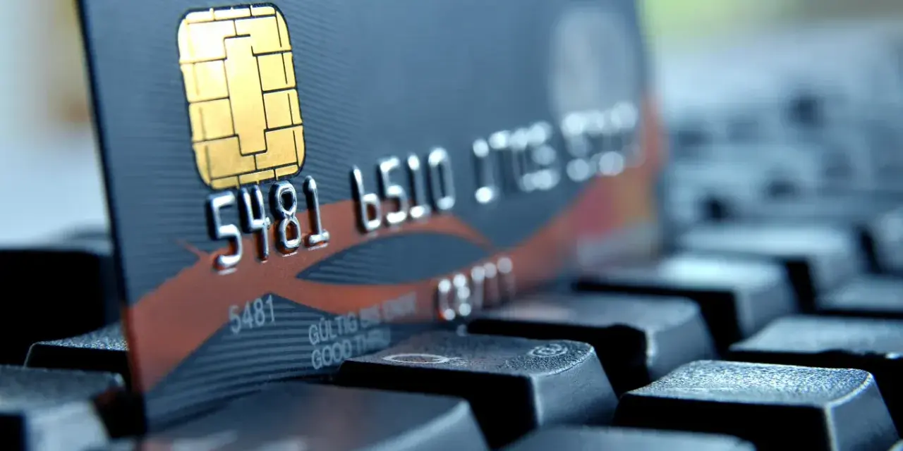 Zbliżenie na kartę płatniczą z numerem 5481 6510. Czy to bank 1750? Karta leży na klawiaturze.