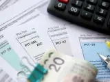 Formularze PIT-36, PIT-37, PIT-38, kalkulator i banknot 20 zł. Czas rozliczyć podatki i poznać pit kwota do zapłaty.