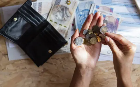 Dłonie liczą monety i banknoty obok otwartego portfela. Szybka, bezpieczna chwilówka to rozwiązanie, gdy brakuje gotówki.