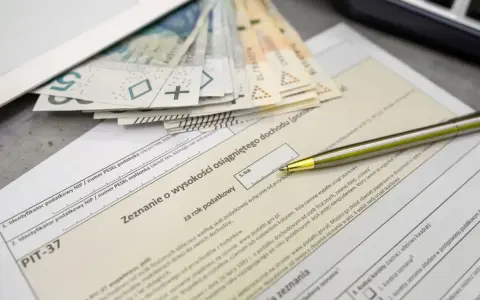 Pieniądze i długopis na formularzu PIT-37. Zbliża się termin rozliczenia, a kwota wolna od podatku ryczałt jest ważnym elementem zeznania.