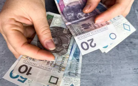 Ręce trzymają polskie banknoty 10, 20 i 50 zł. Czy w Vivus można przedłużyć pożyczkę?