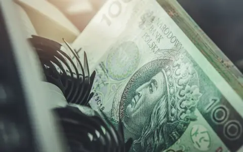 Stos banknotów 100 zł, część mechanizmu maszyny liczącej. Szybkie vivus przelewy w nocy.