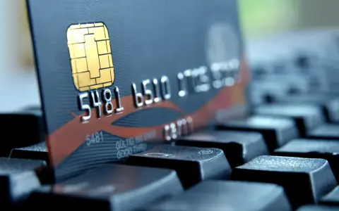 Zbliżenie na kartę płatniczą z numerem 5481 6510. Czy to bank 1750? Karta leży na klawiaturze.