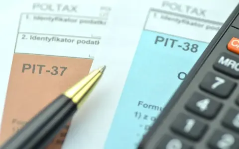 Dwa formularze podatkowe, PIT-38 i PIT-37, leżą obok siebie, gotowe do wypełnienia. Obok leży długopis i kalkulator.