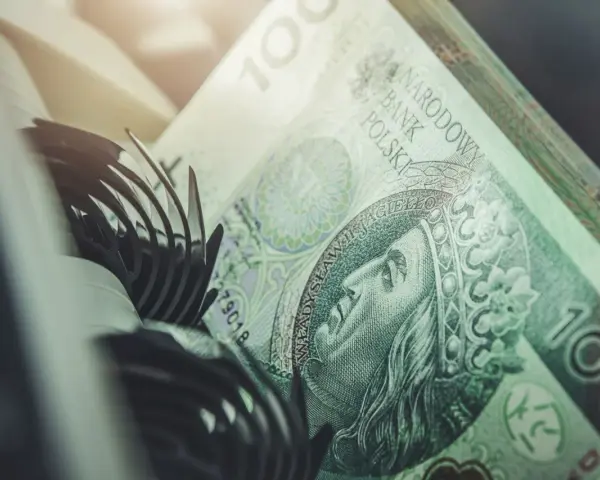 Stos banknotów 100 zł, część mechanizmu maszyny liczącej. Szybkie vivus przelewy w nocy.
