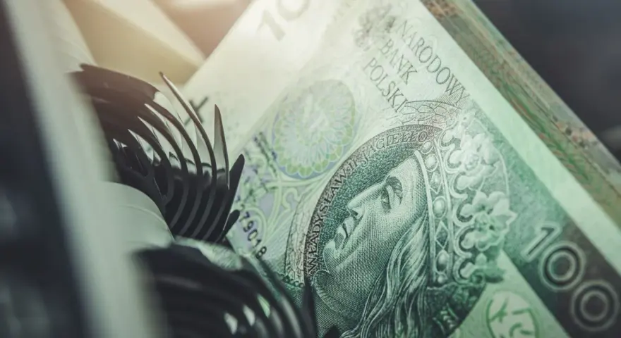 Stos banknotów 100 zł, część mechanizmu maszyny liczącej. Szybkie vivus przelewy w nocy.