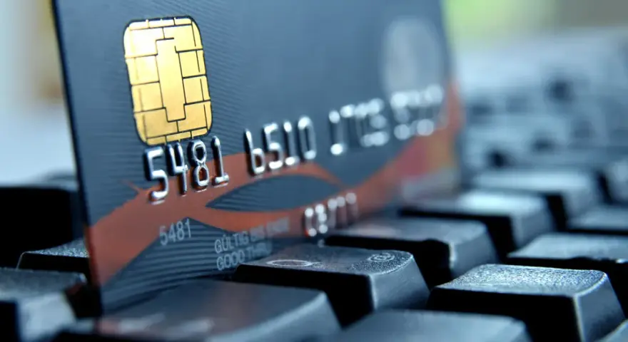 Zbliżenie na kartę płatniczą z numerem 5481 6510. Czy to bank 1750? Karta leży na klawiaturze.