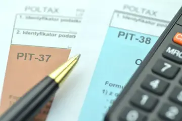 Dwa formularze podatkowe, PIT-38 i PIT-37, leżą obok siebie, gotowe do wypełnienia. Obok leży długopis i kalkulator.